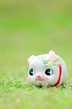 Yeşil çimenlerin üzerinde Çince kumbara