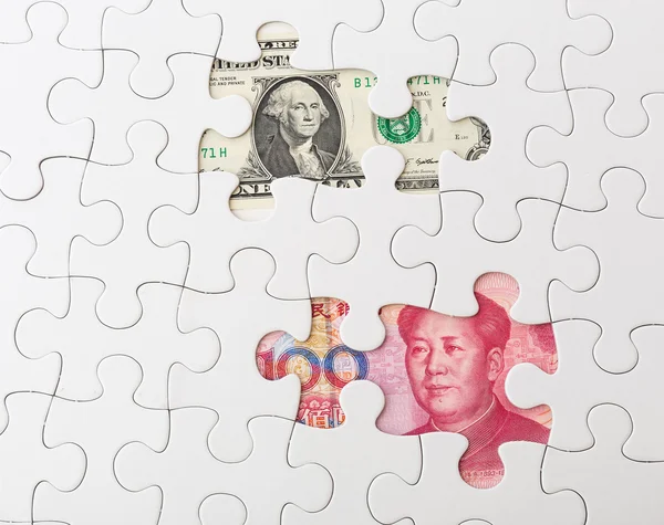 Quebra-cabeça branco com dólar americano e yuan chinês — Fotografia de Stock