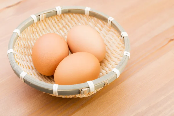 Uovo in cesto con sfondo in legno — Foto Stock