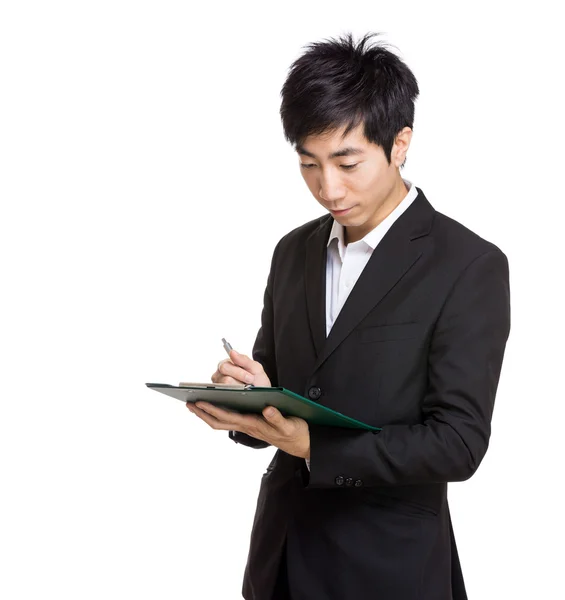 Asian businessman writing on file pad Royalty Free Stock Images