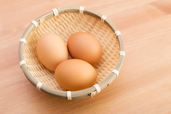 Ei im Korb über Holzgrund — Stockfoto