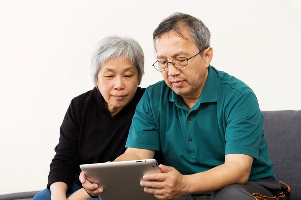 Asiatisches altes Paar liest auf Tablet — Stockfoto