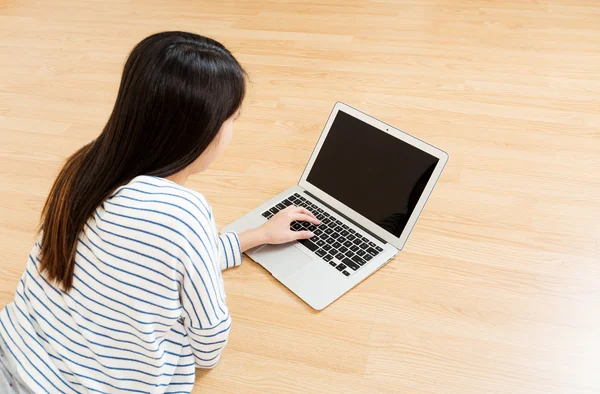 Жінка використовує ноутбук на підлозі — стокове фото