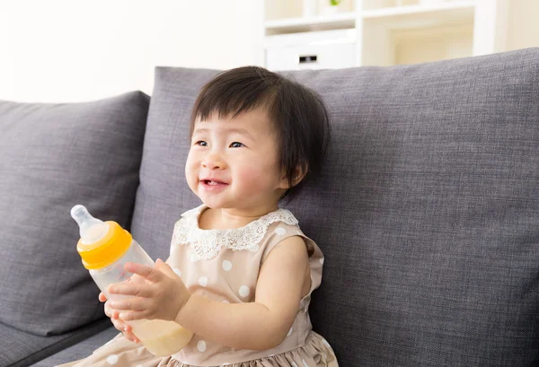 Asiático bebê segurando mamadeira de leite em casa — Fotografia de Stock