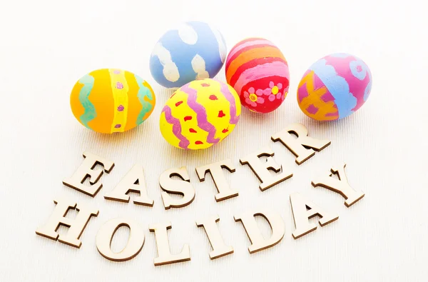 Coloridos huevos de Pascua patterm con letras de madera — Foto de Stock
