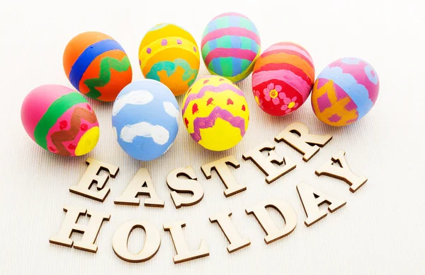 Huevos coloridos de Pascua con texto de madera — Foto de Stock