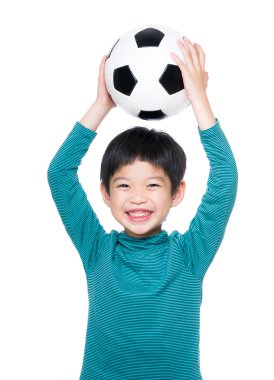 Asyalı küçük çocuk futbol topunu tutan