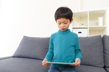 Asyalı küçük çocuk evde tablet kullanma