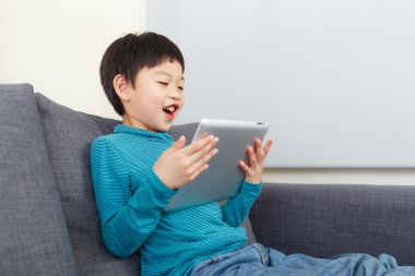 Asyalı küçük çocuk tablet üzerinde oyun oynama