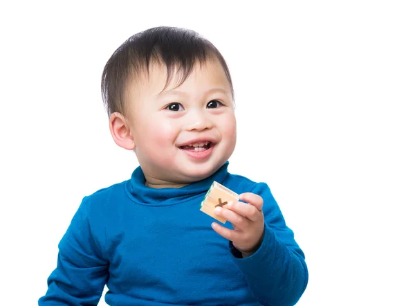 Азиатский мальчик улыбается и держит деревянный игрушечный блок — стоковое фото