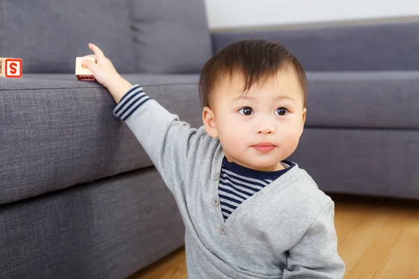 Asiático bebé niño sosteniendo un juguete bloque en casa —  Fotos de Stock