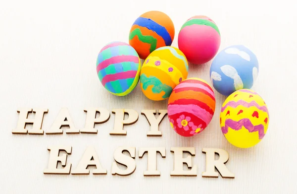 Painted easter eggs with wooden text — Stock Photo, Image