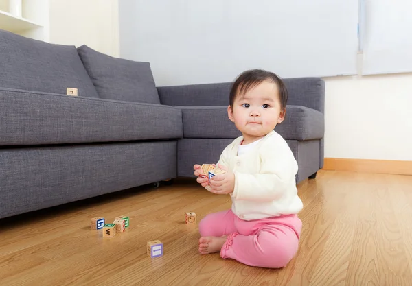 Азиатская девочка играет с игрушечными блоками дома — стоковое фото