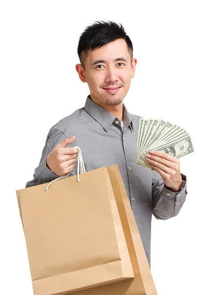 Asyalı adam elinde nakit para ile alışveriş çantası — Stok fotoğraf
