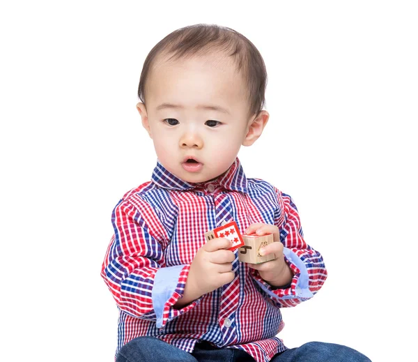 Niño sosteniendo bloque de juguete de madera y mirando a un lado — Foto de Stock