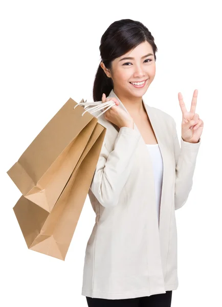 Frau hält Einkaufstasche in der Hand und gibt Siegeszeichen — Stockfoto