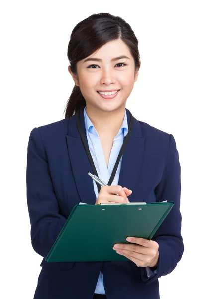 Businesswoman writing on clipboard — Stock Photo, Image