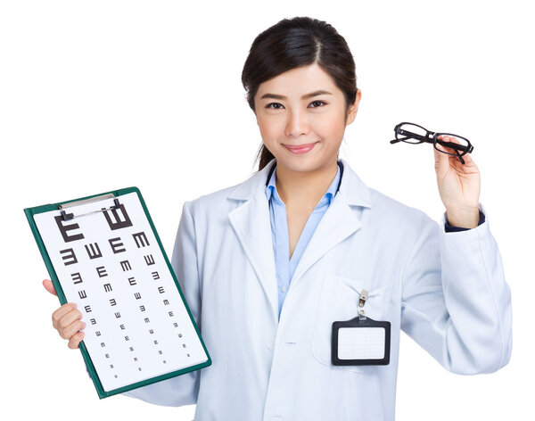 Optometrist showing eye exam chart and holding glasses