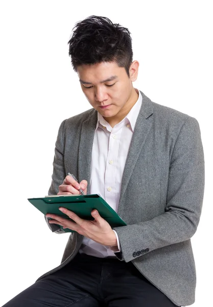 Businessman making note on clipboard Stock Photo