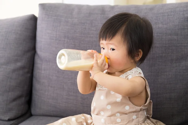 Прелестная малышка пьет молоко из бутылки — стоковое фото