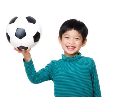Futbol topu tutan genç bir çocuk.