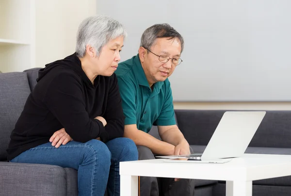 Senior koppel werken met laptop thuis — Stockfoto