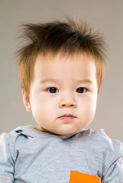 Азиатский мальчик на сером фоне — стоковое фото