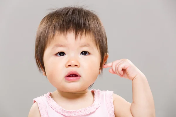Meisje van de baby touch haar oor — Stockfoto