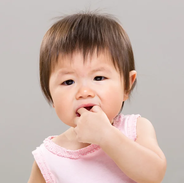 Маленькая девочка кусает палец — стоковое фото
