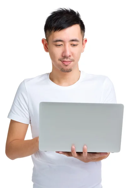 Ung asiatisk man tittar på laptop — Stockfoto