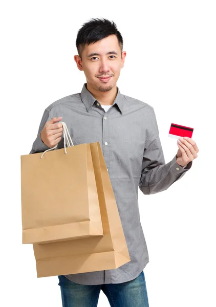 Hombre de compras sosteniendo bolsa de papel y tarjeta de crédito —  Fotos de Stock