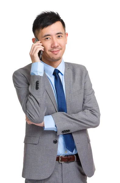 Smiling young businessman answering phone — Stock Photo, Image