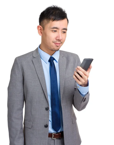 Азиатский бизнесмен смотрит на мобильный телефон — стоковое фото