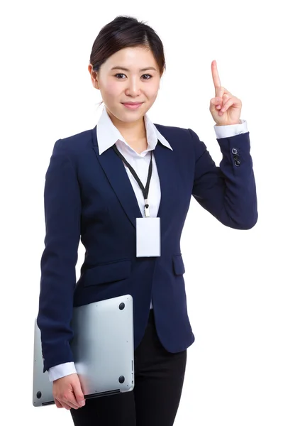 Empresária segurando laptop com o dedo apontando para cima — Fotografia de Stock
