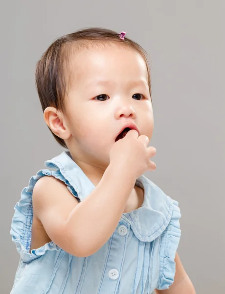 Baby girl put finger into mouth — Stock Photo, Image