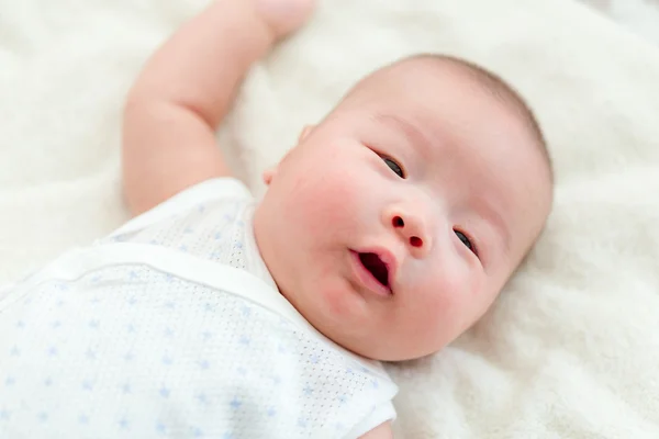 Baby is lying on carpet — Stock Photo, Image