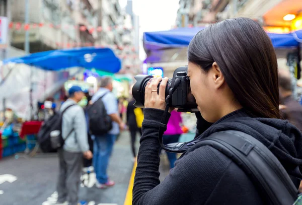 Vrouwelijke toeristische nemen foto met camera in street op hong kong — Stockfoto