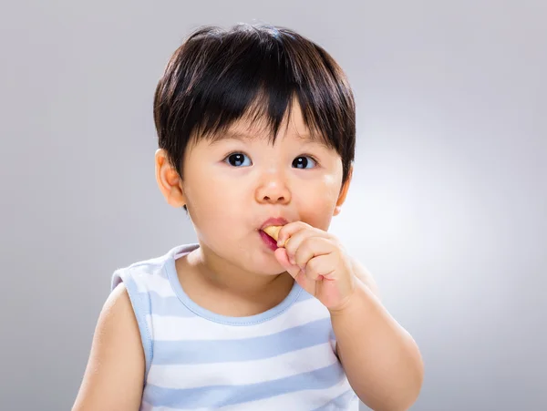 Baby boy eating biscuit — Stock Photo, Image