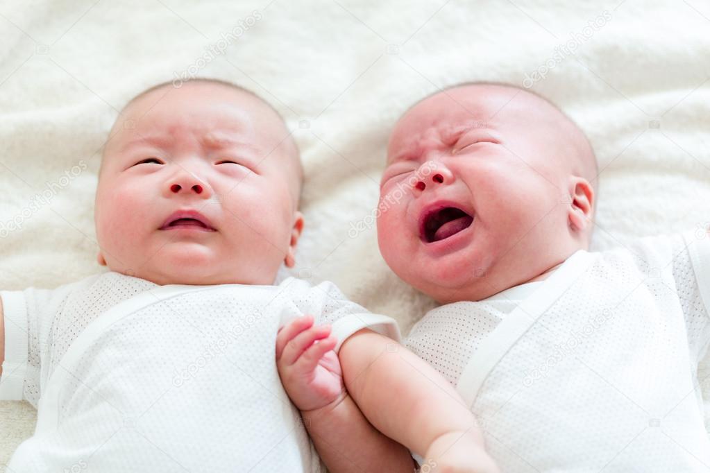 Baby twins, one crying and one quiet