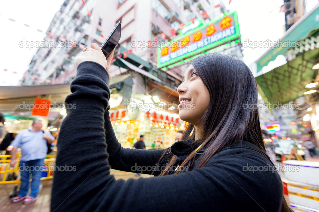 Woman taking selfise in street market