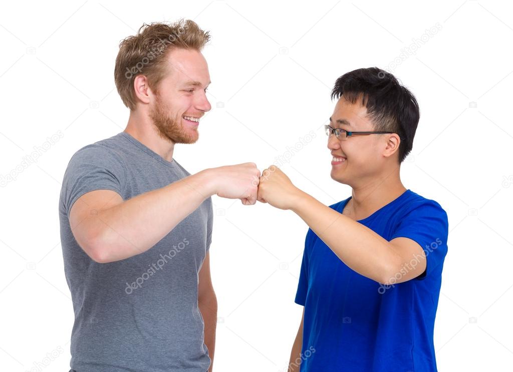 Two arm fist punch each other for caucasian and asian man 