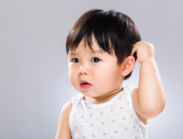 Surprised baby scratching head — Stock Photo, Image