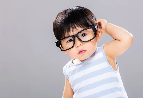 Niño con gafas y rascándose la cabeza — Foto de Stock