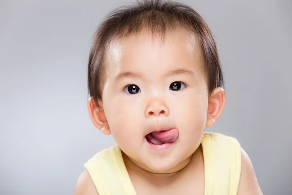 Asian baby girl with lick sticking out — Stock Photo, Image
