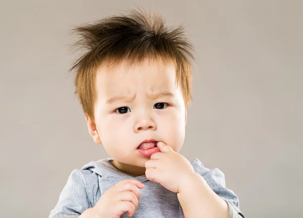 Little boy put finger into mouth — Stock Photo, Image