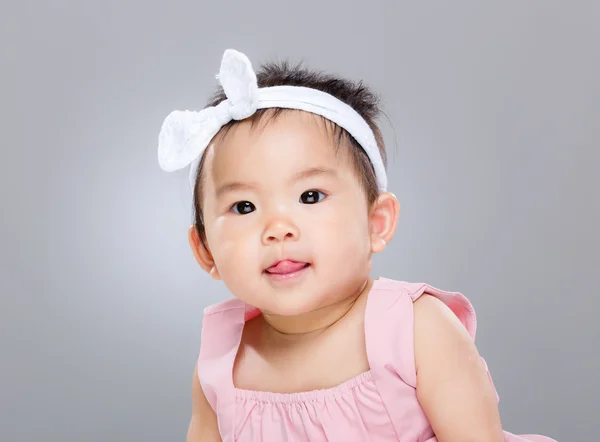 Adorable baby girl with lick sticking out — Stock Photo, Image