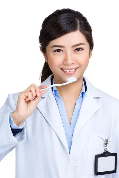 Female dentist holding toothbrush — Stock Photo, Image