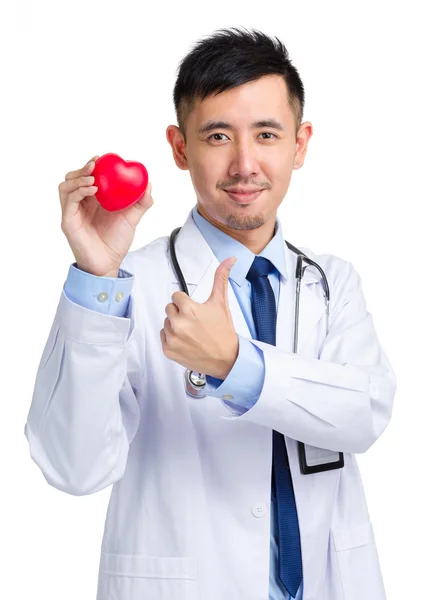 Doctor holding heart shape toy and thumb up — Stock Photo, Image