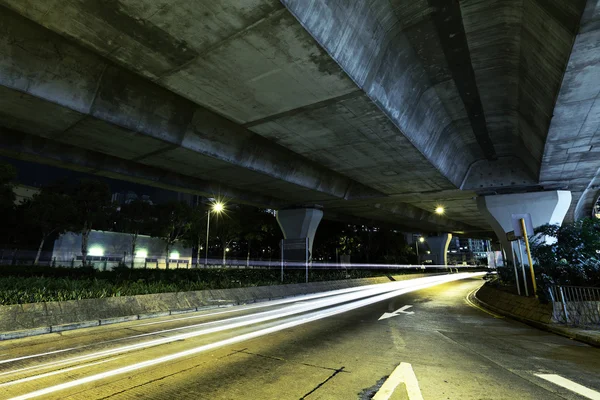 Car light trail under highway — Stock Photo, Image