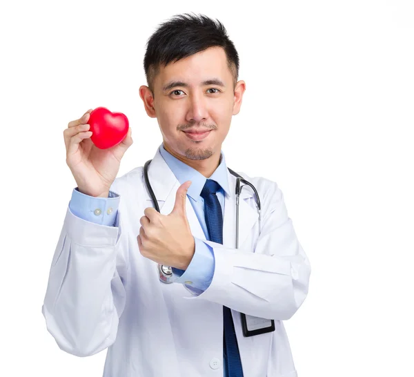 Kırmızı kalp ve başparmak ile erkek doktor — Stok fotoğraf